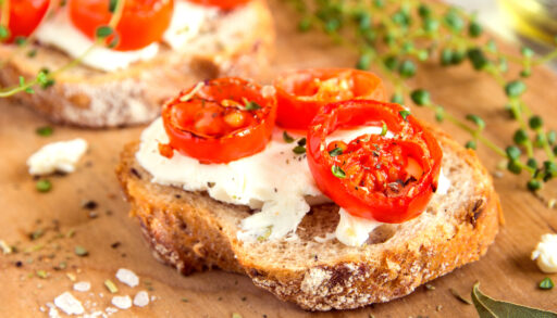 Sliced tomato roasted on goat cheese and a slice of bread