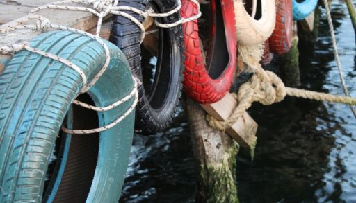 Colourful tires hanging on the right side of a dock
