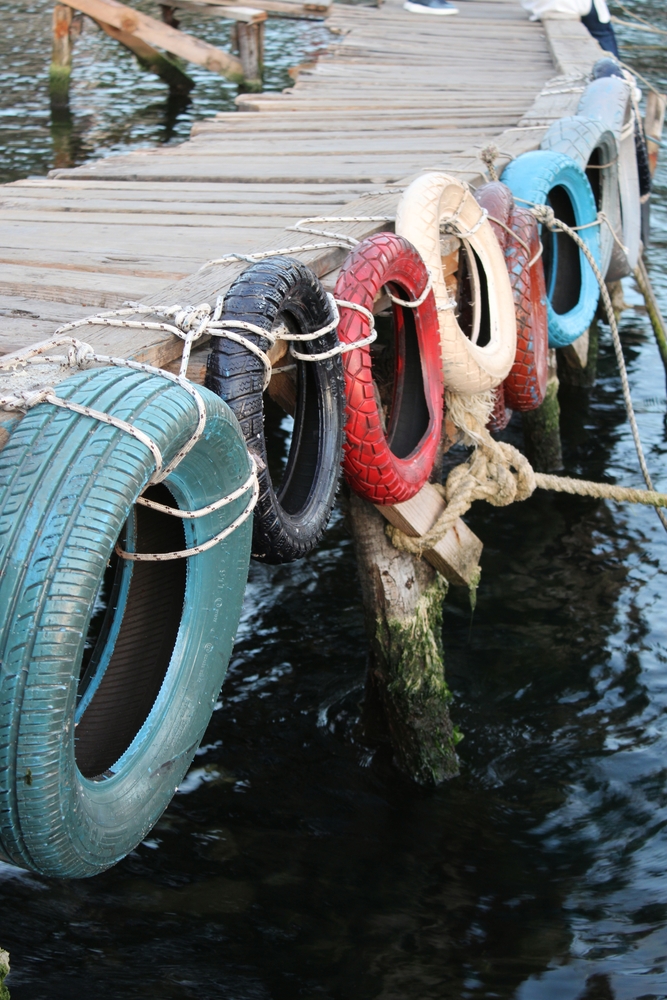 Colourful tires hanging on the right side of a dock