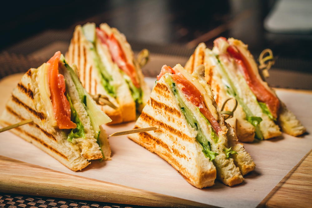 Four chicken club sandwiches on cutting board