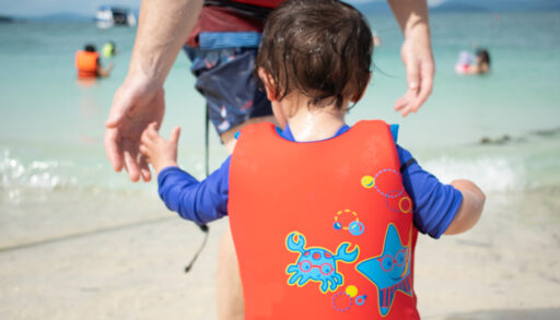 Baby wearing a red lifejacket.