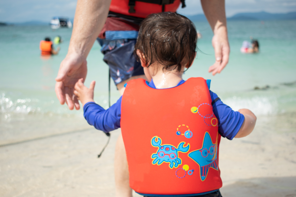 Baby wearing a red lifejacket.