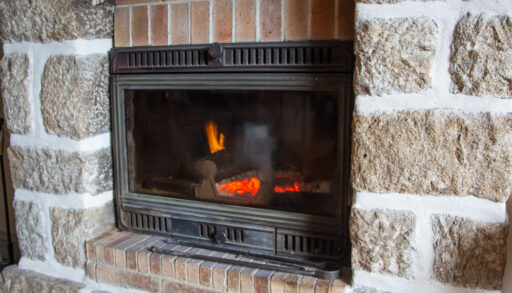 Built-in wood-burning fireplace surrounded by stonework.