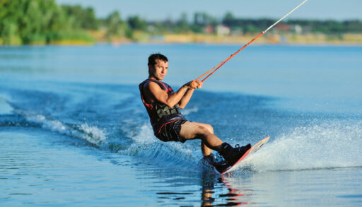 Wakeboarder on a lake with trees in the background.