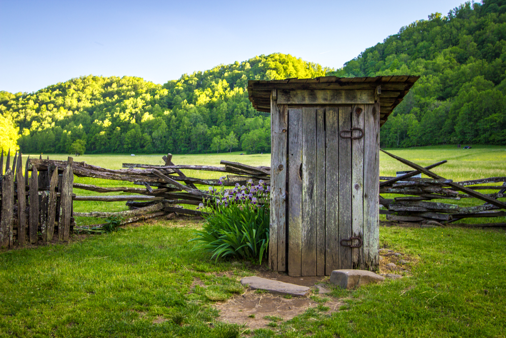 Wooden outhouse on field