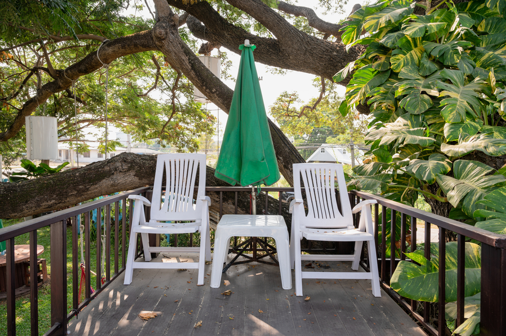 White plastic patio chairs on back porch