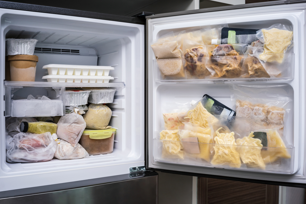 Close-up of a fridge freezer filled with food.