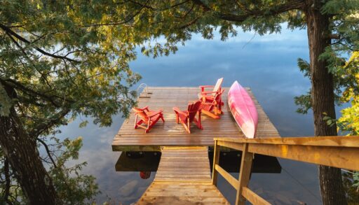 Stairs leading down to a lakeside dock and canoe.