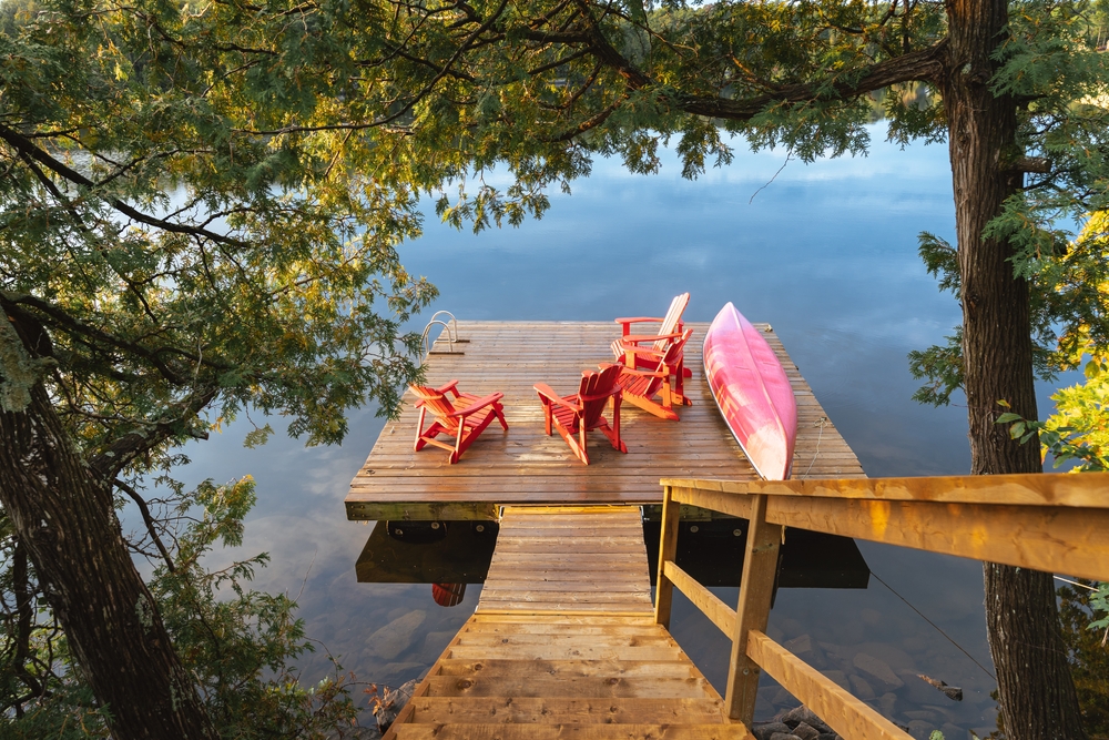 Stairs leading down to a lakeside dock and canoe.