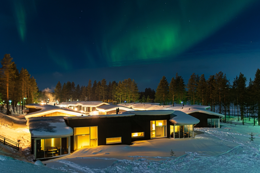 Cottage in snow under northern lights