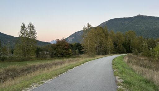 A paved road running through a mountainous landscape at dusk.