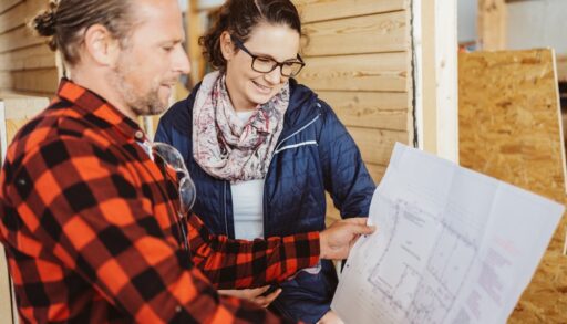 Male contractor going over building plans with a female homeowner.