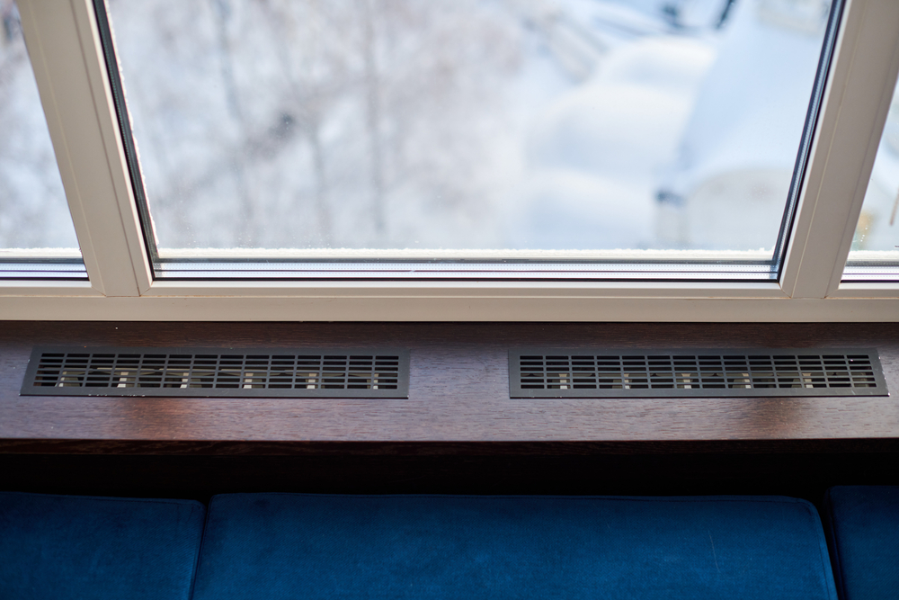 Overhead view of a baseboard heater underneath a window.