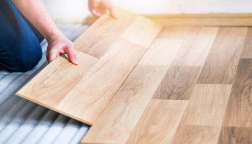 Person laying laminate flooring.