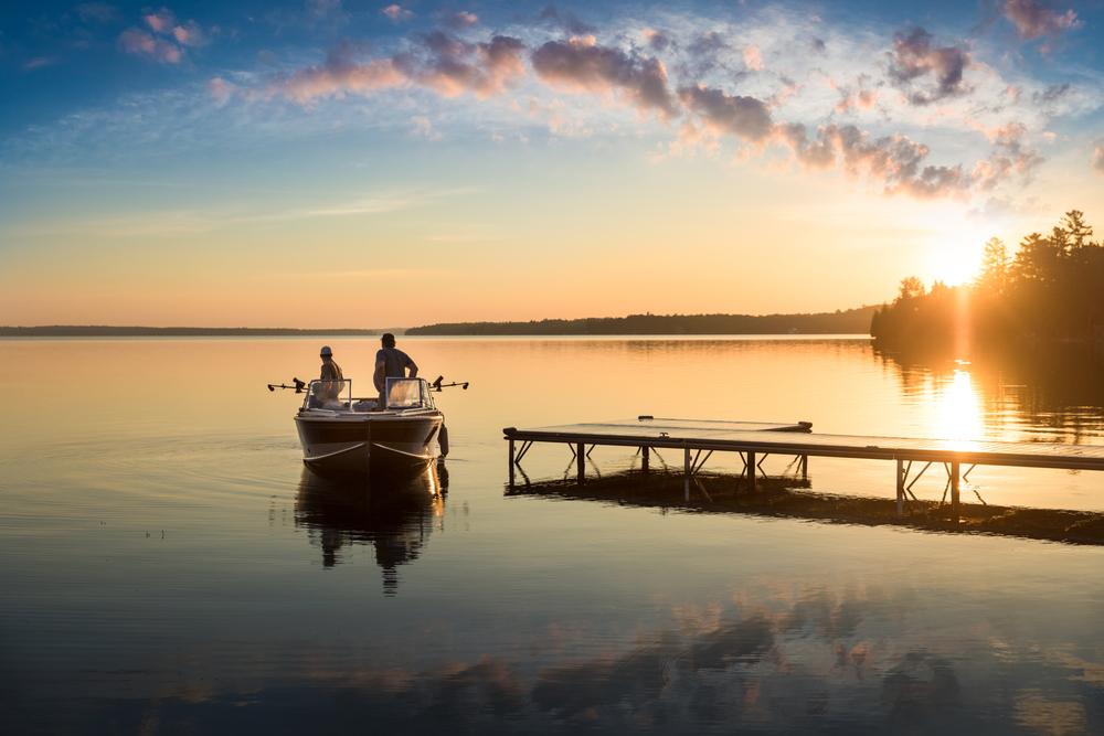 Cottage Life - Father and son fishing on a boat at sunrise/sunset at the peaceful cottage in Kawartha Lakes Ontario Canada on Balsam Lake