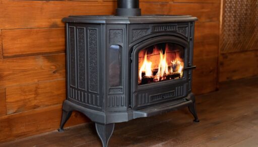 Close-up of a wood-burning stove in a room with wood panelling.