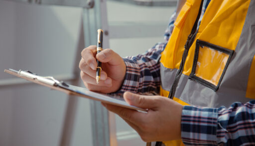 Man in an orange vest going through a checklist.