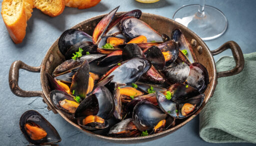Cooked blue mussels in a cast iron pan.