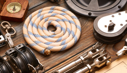Flat-lay of various boating supplies including rope and a compass.