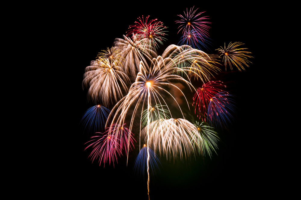 Different coloured fireworks light up a night sky.