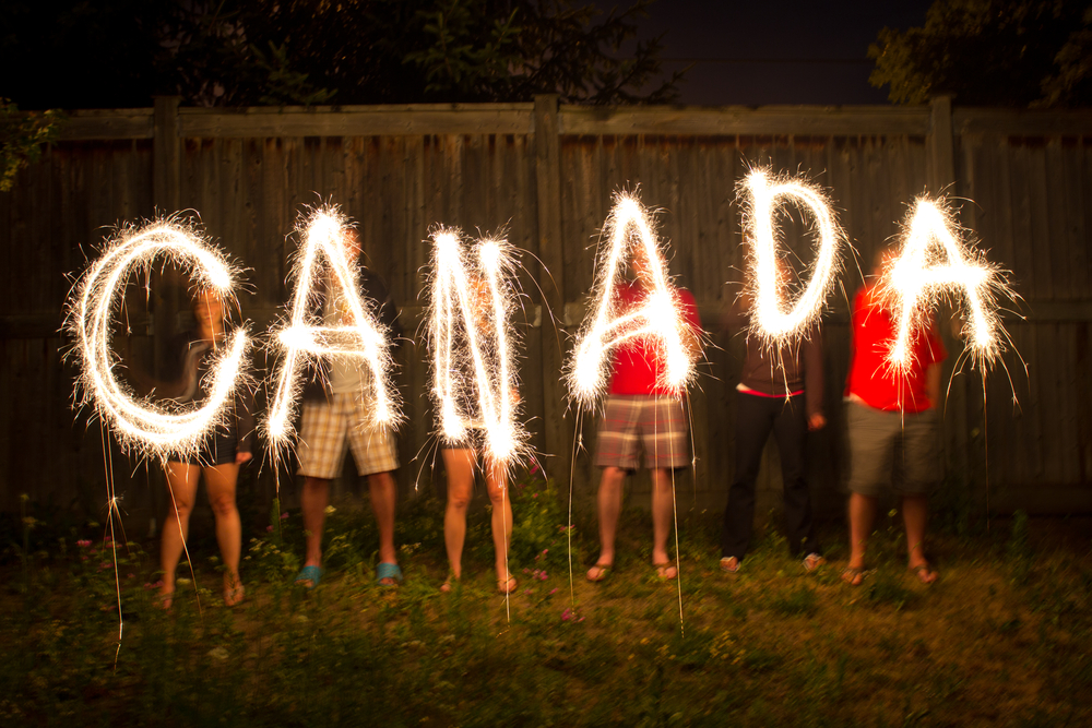 People holding sparklers spelling Canada.