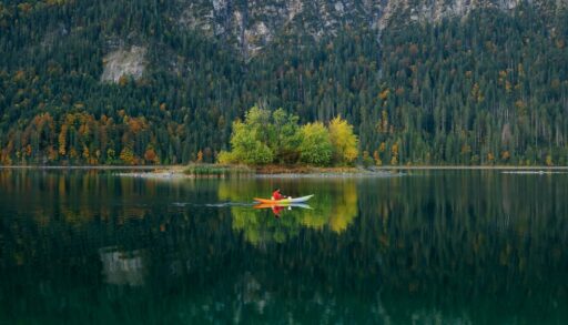Man kayaking on a lake in autumn.