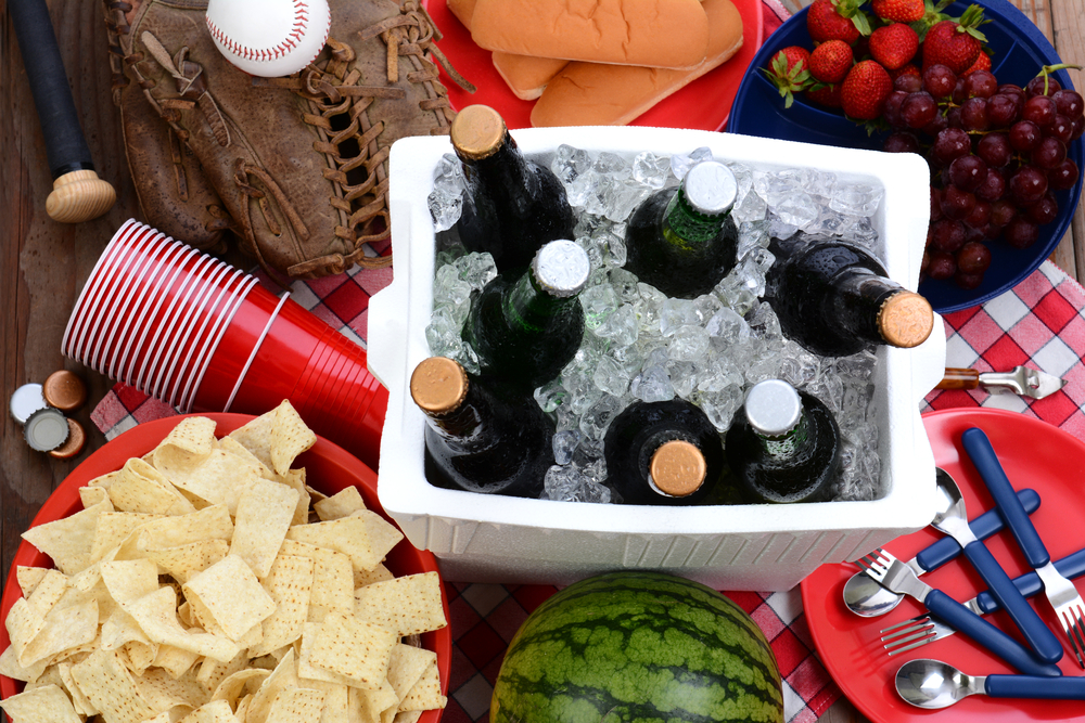 Overhead view of a cooler with beer bottles on a picnic table.