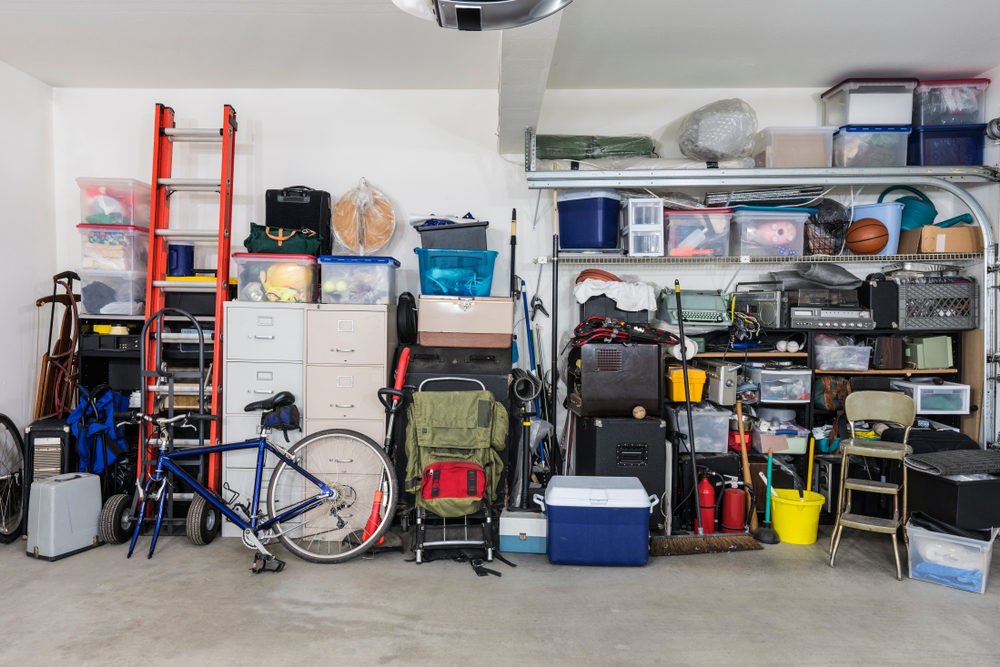 Garage filled with various items like a ladder, bike, cooler and yard supplies.
