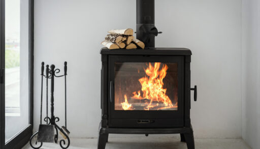 Black wood burning fireplace next to a window.