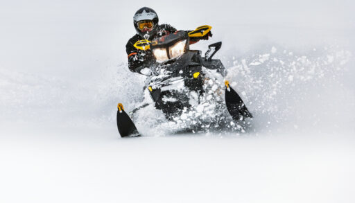 Person riding a snowmobile in deep snow.