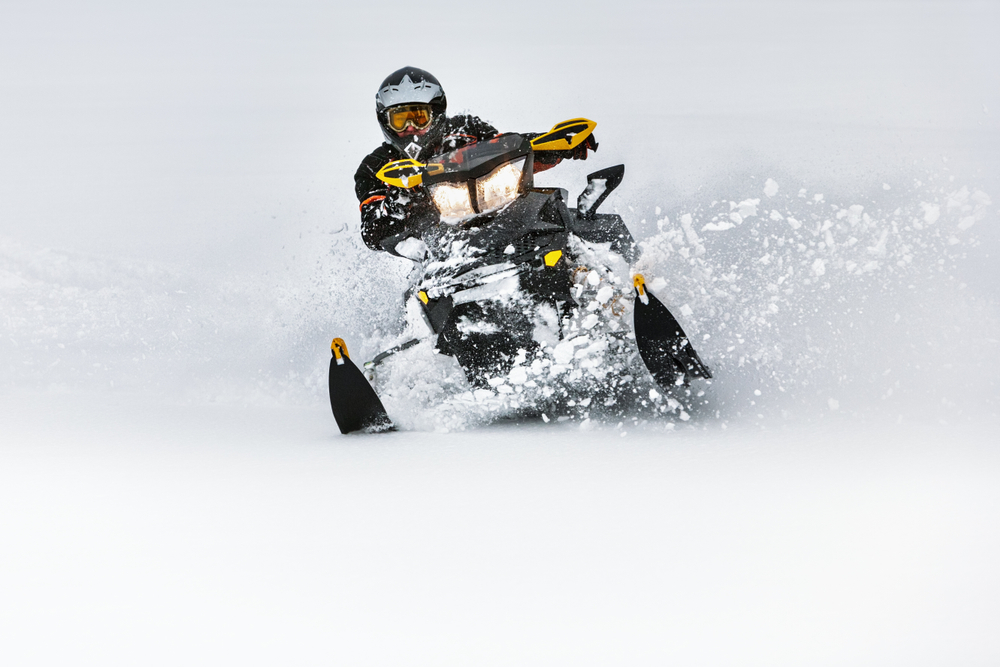 Person riding a snowmobile in deep snow.