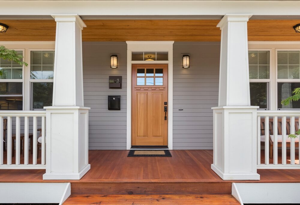 Front view of a wooden door with a white and wood porch.