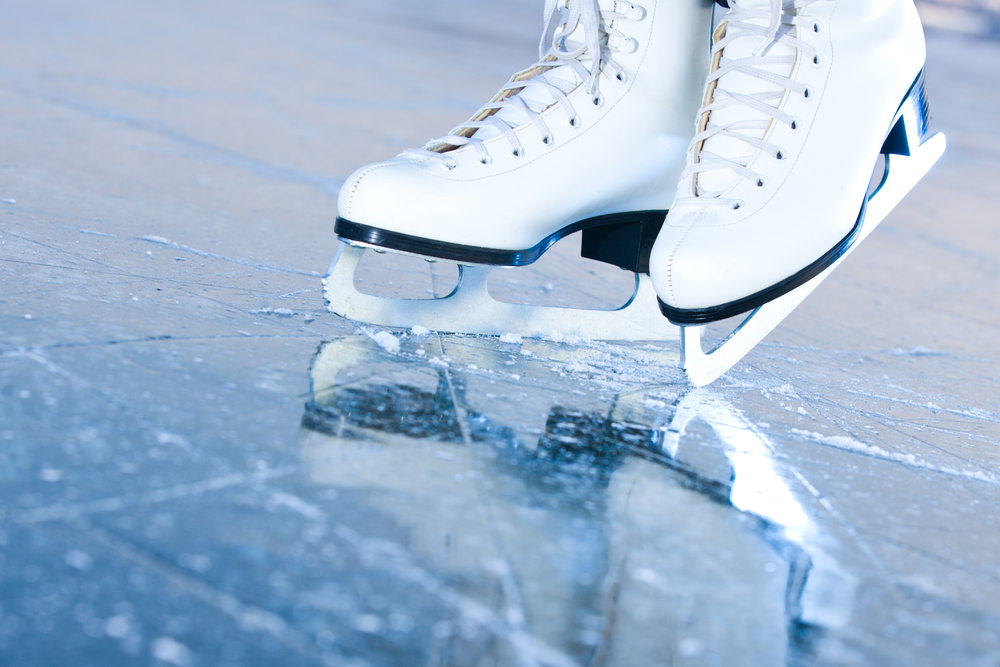 Close-up on figure skates in blue ice.