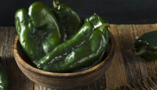 Green poblano peppers in a wooden bowl.
