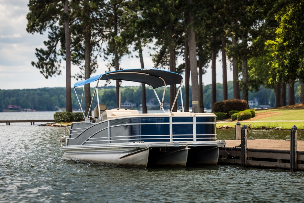 Pontoon boat anchored next to a private dock.