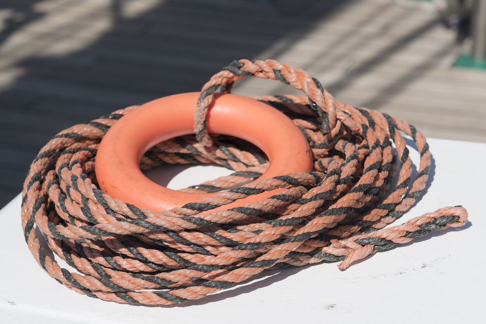 Orange life buoy and orange and black rope.