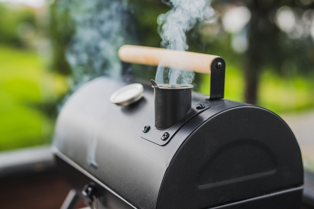 Close-up of smoke coming from a black smoker.