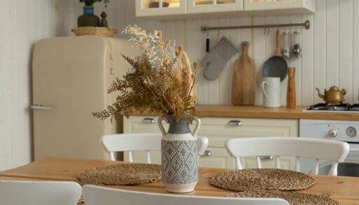 White kitchen with a tan-coloured fridge and a wooden dining table.