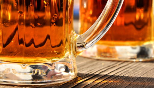 Close-up of bottom of beer glasses on a table.