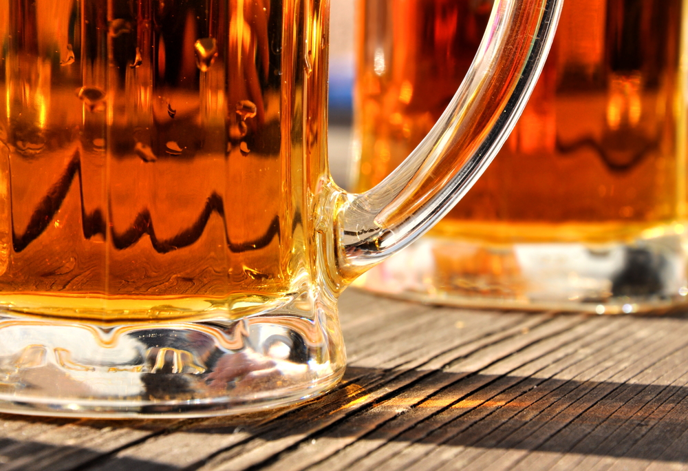 Close-up of bottom of beer glasses on a table.