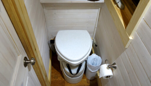 White composting toilet in a small bathroom.