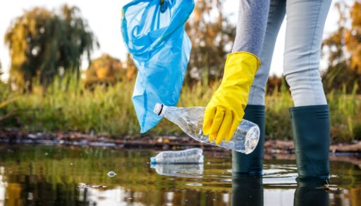 Person picking up waste from a lake.