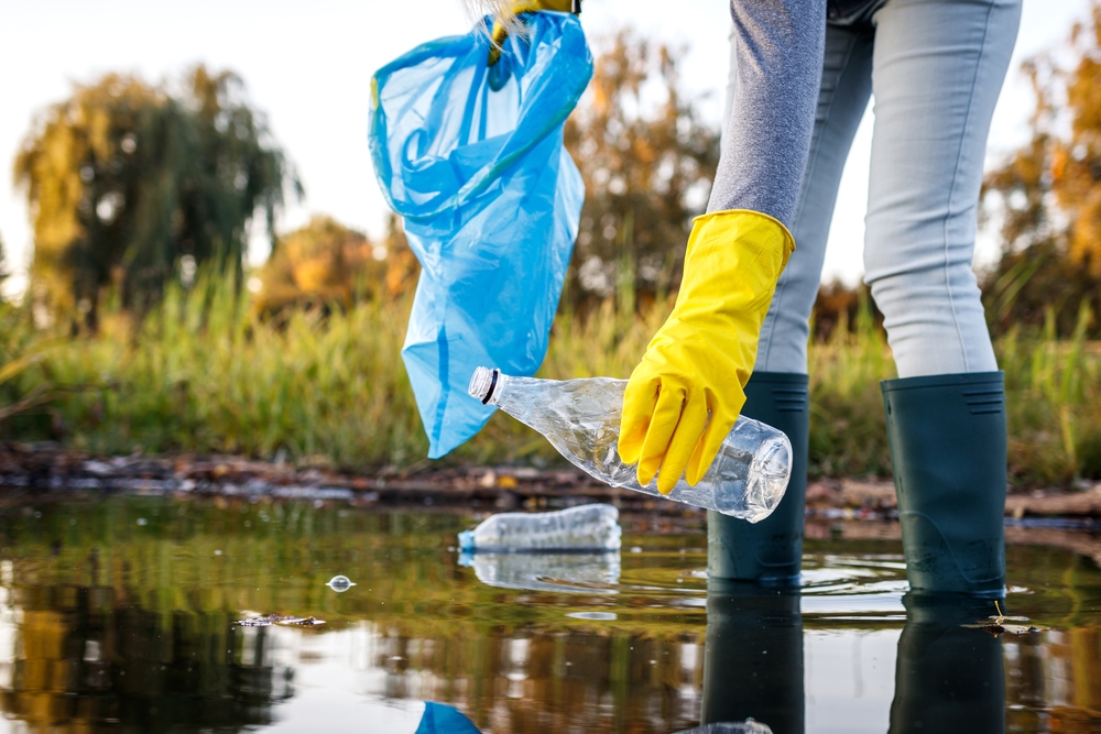 Person picking up waste from a lake.
