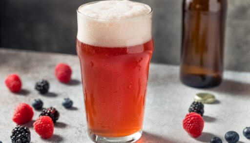 Red-coloured beer shandy in a pint glass.