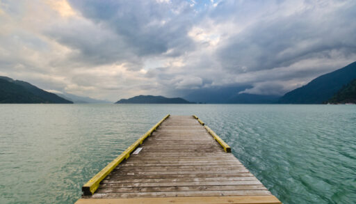 View looking down a wooden dock on a lake.