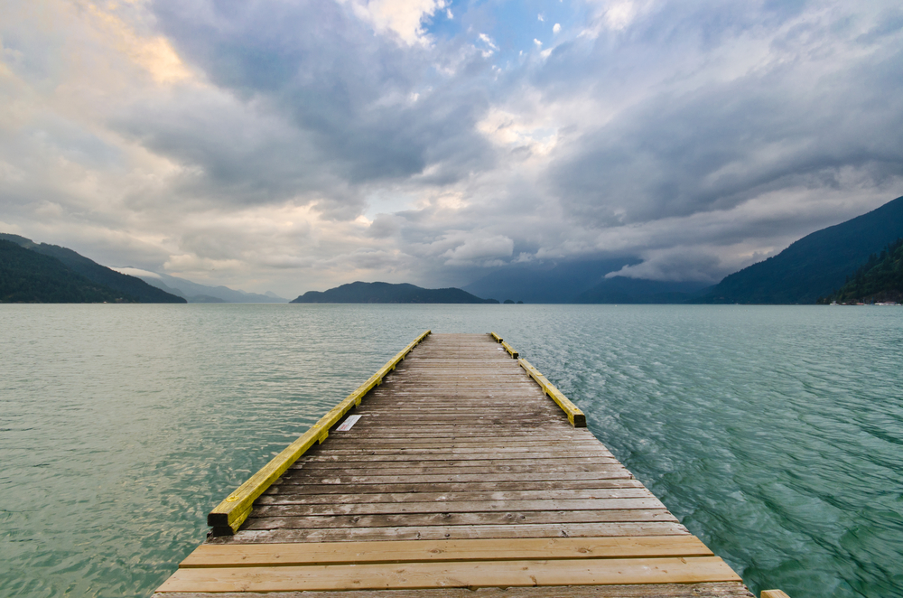 View looking down a wooden dock on a lake.
