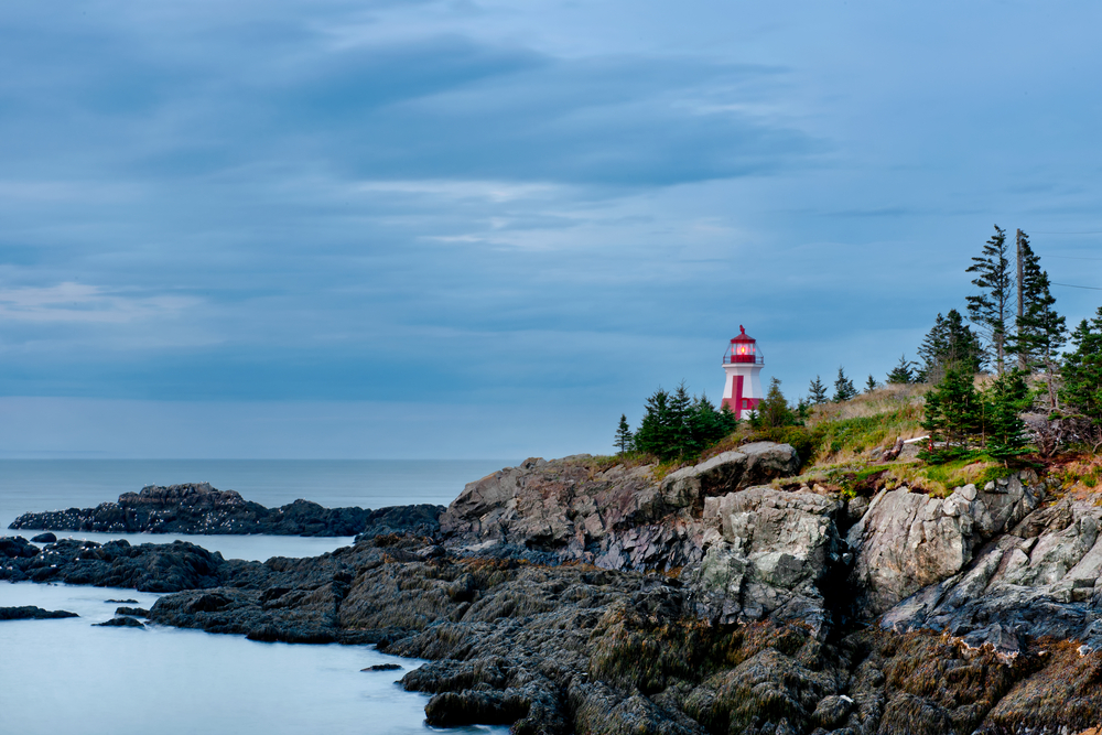View of the Head Harbour Lightstation on rocky cliffs in New Brunswick, Canada.