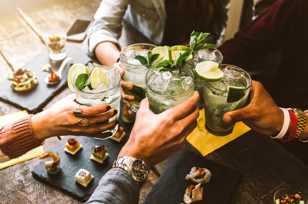 Group of people raising glasses at a dinner table.