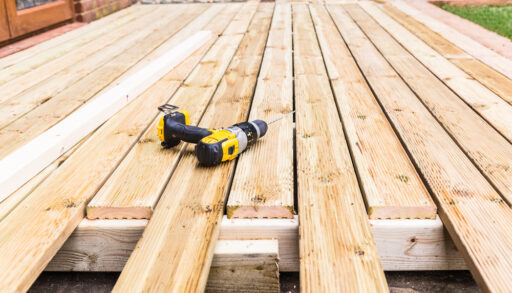 Wooden deck under construction with a drill on top.