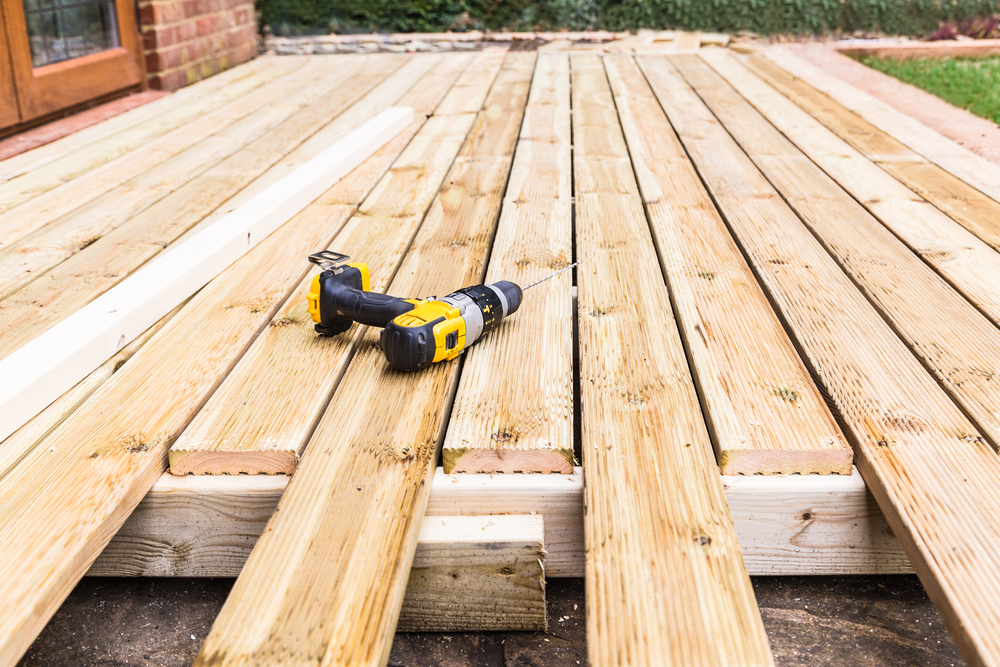 Wooden deck under construction with a drill on top.